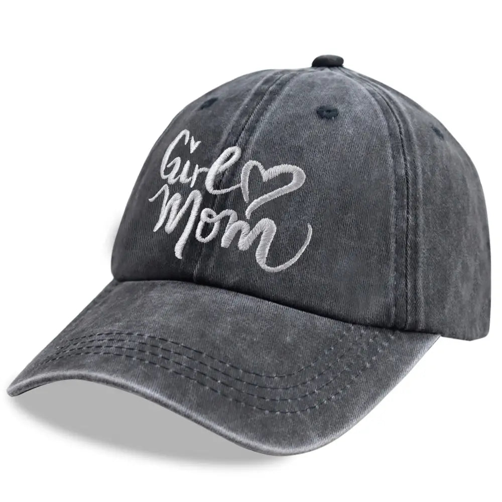 Une casquette de baseball réglable grise délavée à l’aspect vieilli avec l’inscription « girl mom » brodée en blanc en script cursif et un symbole en forme de cœur.