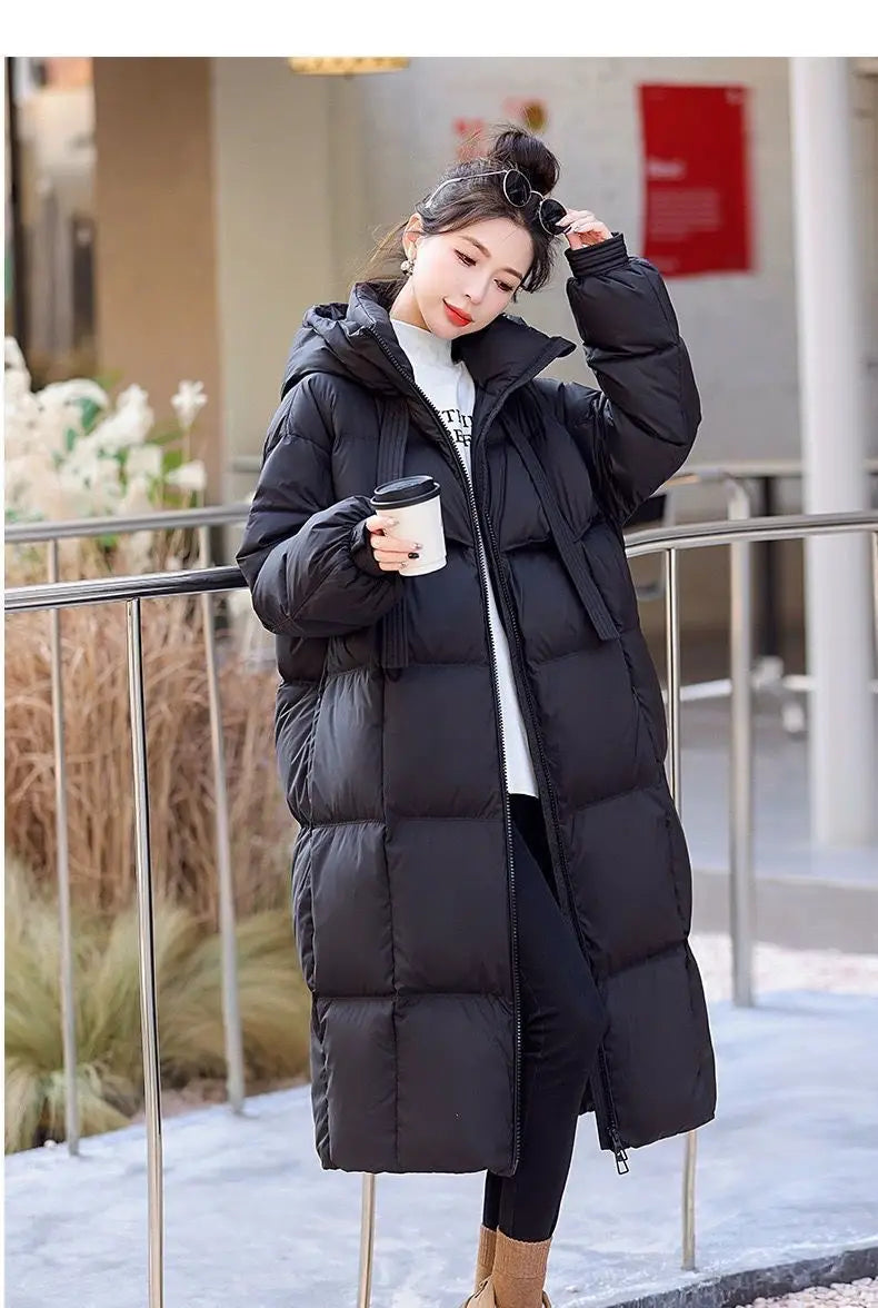 Women long hooded puffer coat in black featuring a quilted design and warm insulated material for cold weather.
