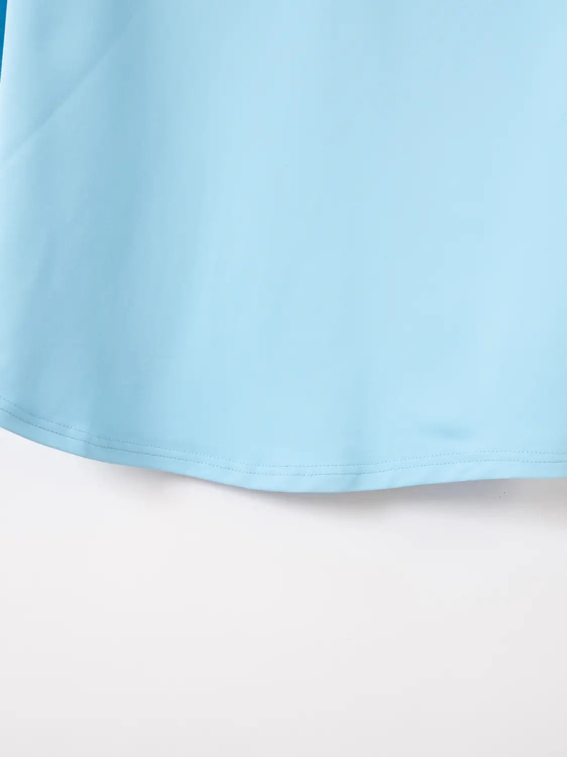 Ein weiches hellblaues Herren-Quarter-Zip-Athletik-Poloshirt aus glattem, fließendem Stoff mit ordentlich verarbeitetem Saumabschluss.