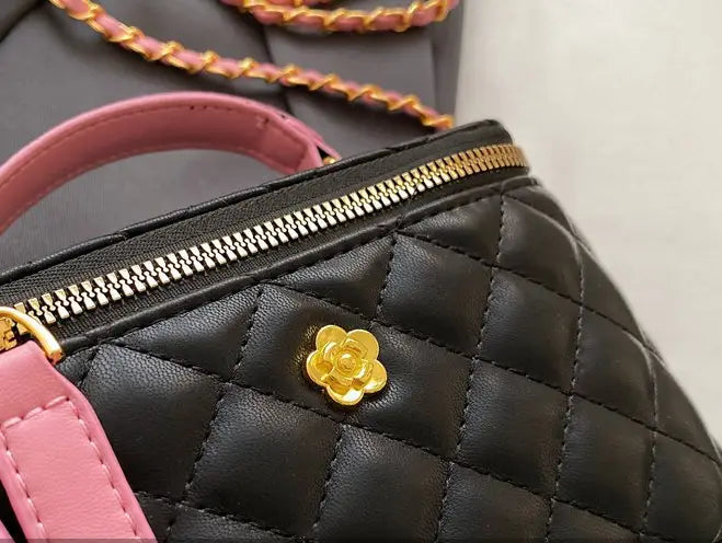 Black quilted diamond chain crossbody bag made of pu leather featuring pink straps and a gold-tone floral clasp.