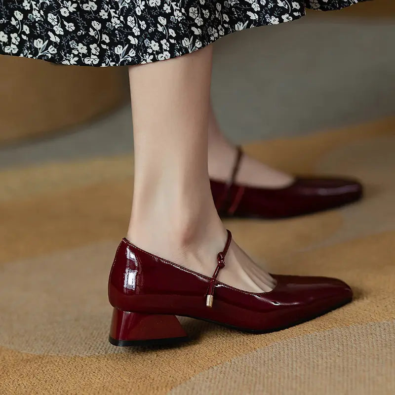 Square toe mary jane patent leather block heels in burgundy with a low heel and gold-tone buckle detail.