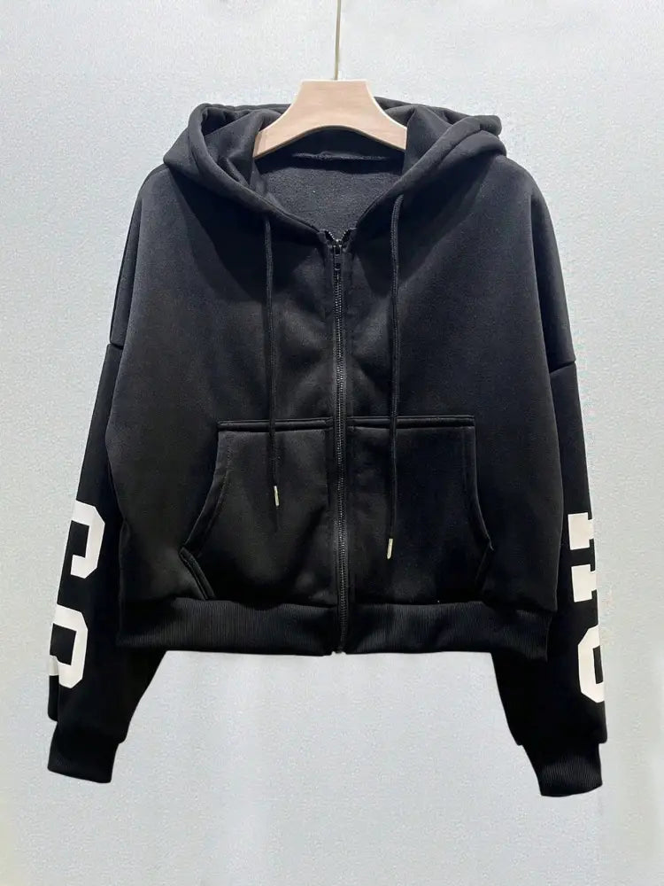 Sweat-shirt à capuche zippé imprimé graphique noir court avec capuche, avec des graphiques numériques blancs sur les manches et des poches zippées avant.