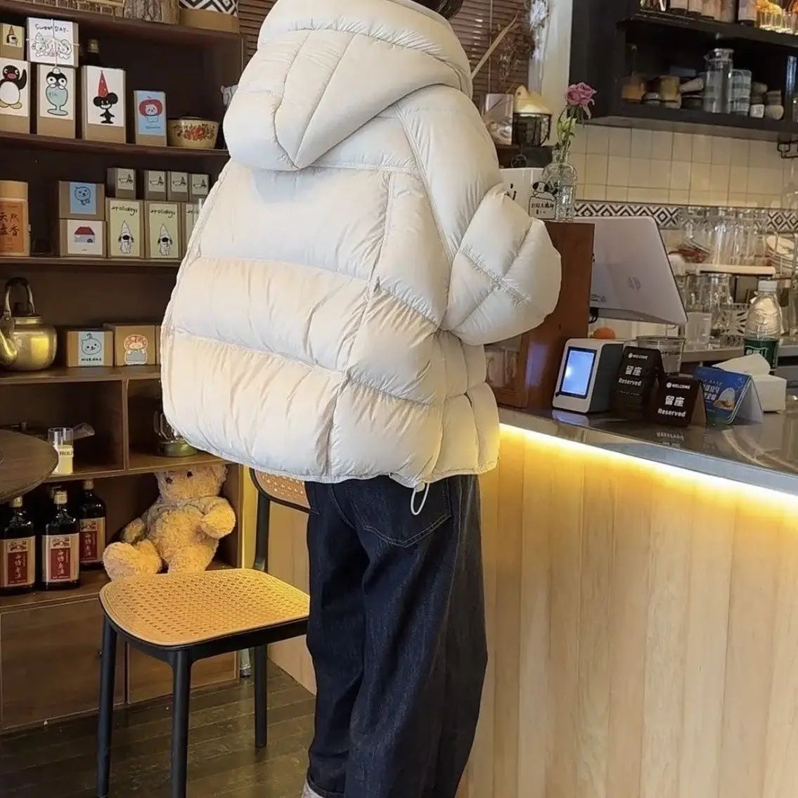 Una chaqueta acolchada de plumón blanca marfil, cómoda, con diseño acolchado y capucha incorporada, incluida en la colección de chaquetas de invierno acolchadas de plumón moradas para mujer.