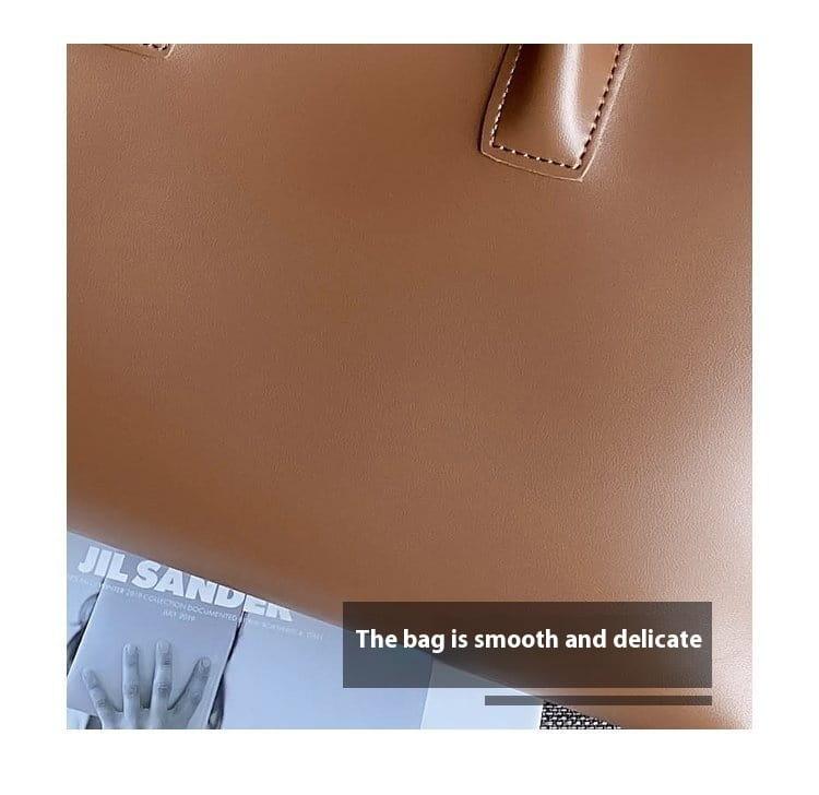 A vintage structured leather tote bag in smooth tan with subtle stitching along its top handles.