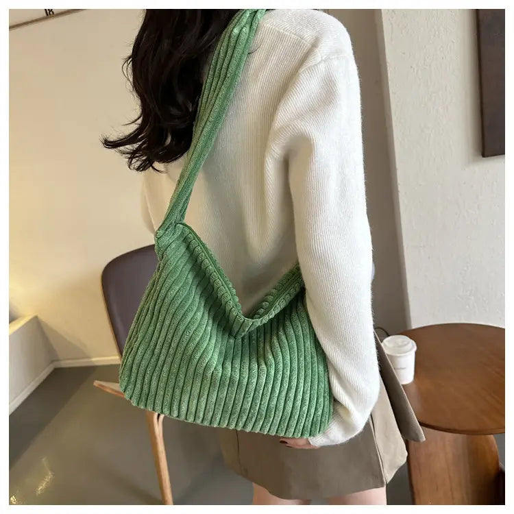 Weicher grüner Corduroy-Schulterbeutel mit gerippter Textur und lässigem, nachgiebigem Design, perfekt für minimalistisches Streetwear.