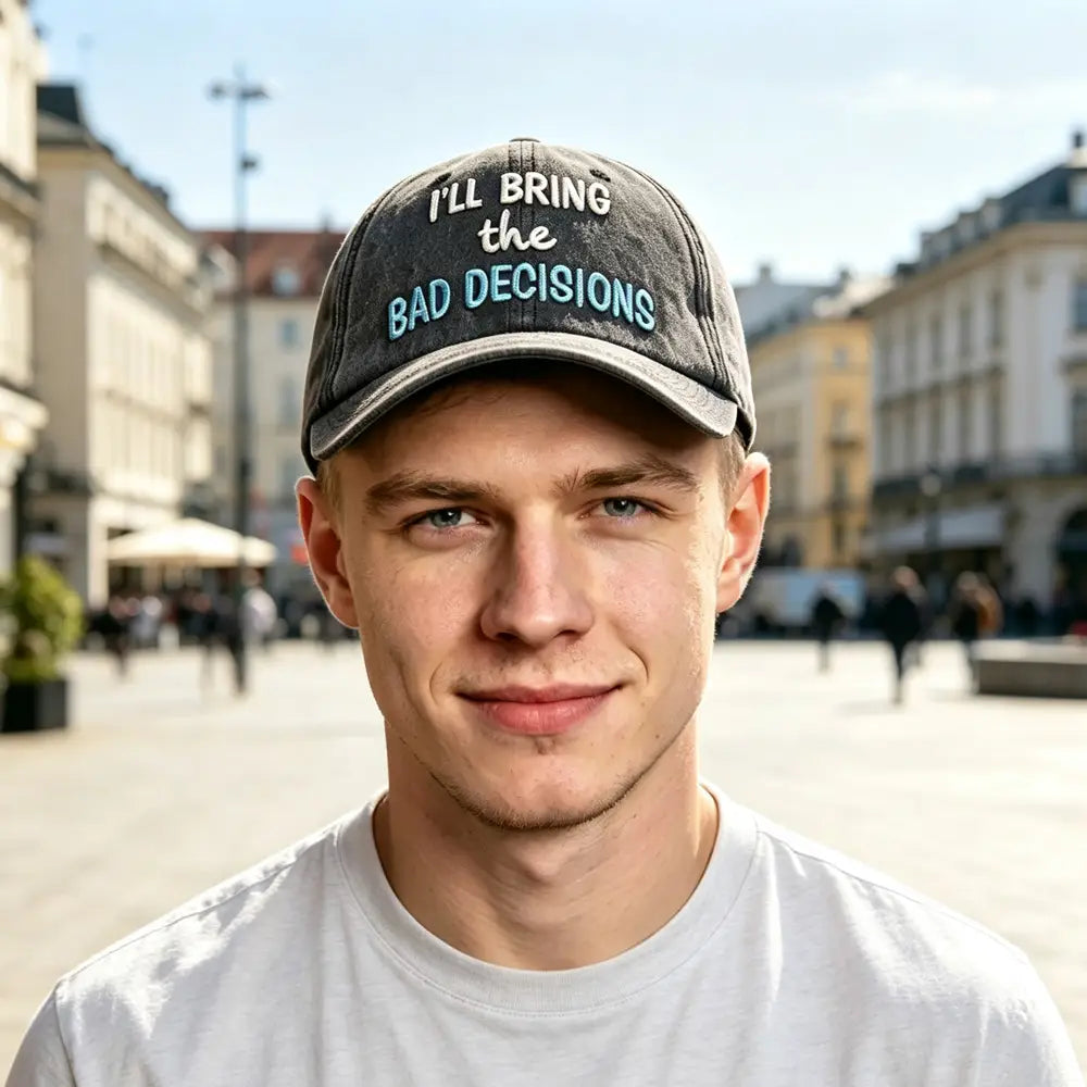 a faded black distressed baseball cap featuring embroidered white and teal text saying ill bring the bad decisions, designed for casual wear.