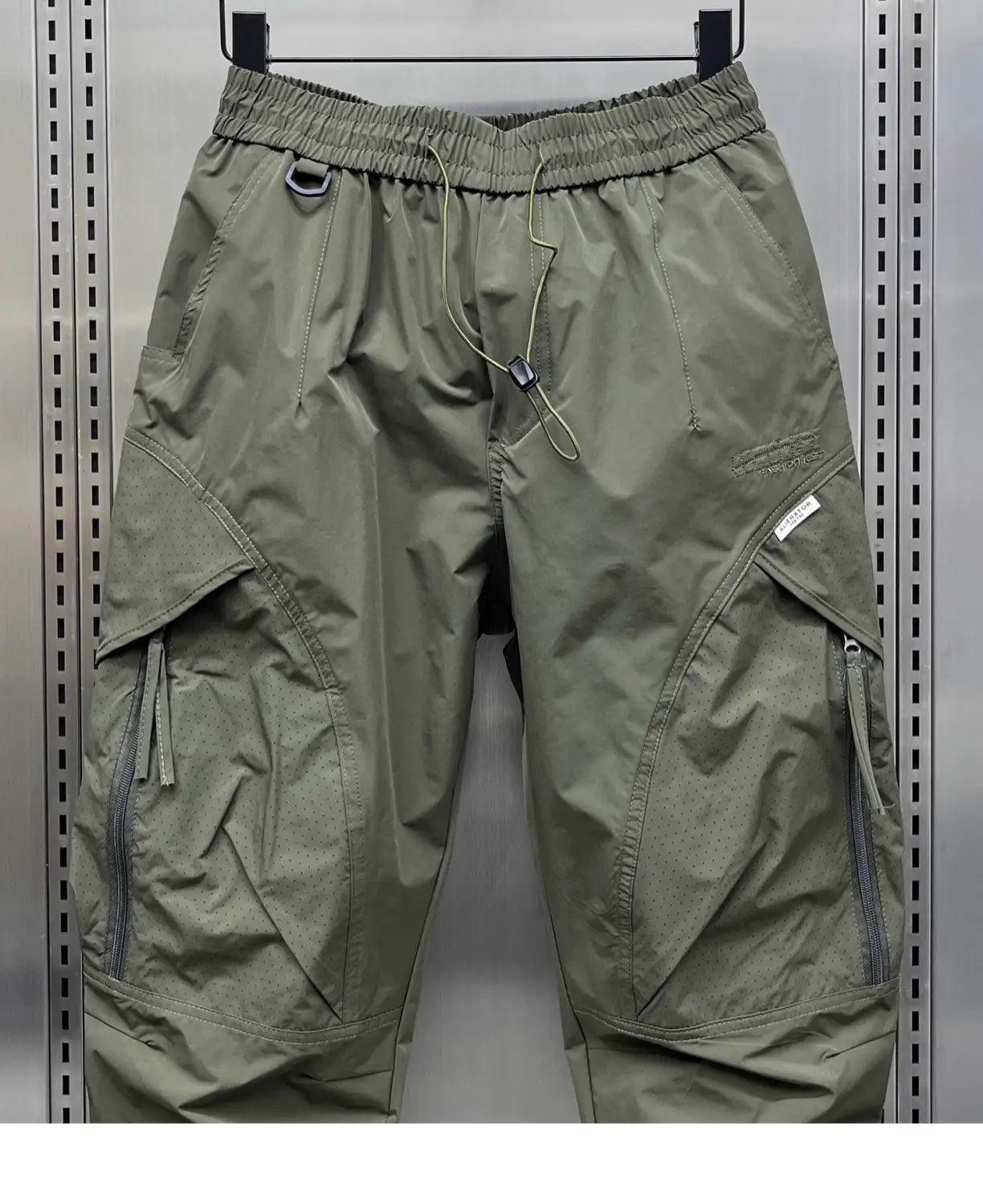 men’s olive green tapered cargo joggers featuring multiple zippered pockets and an elastic waistband for comfort and utility.