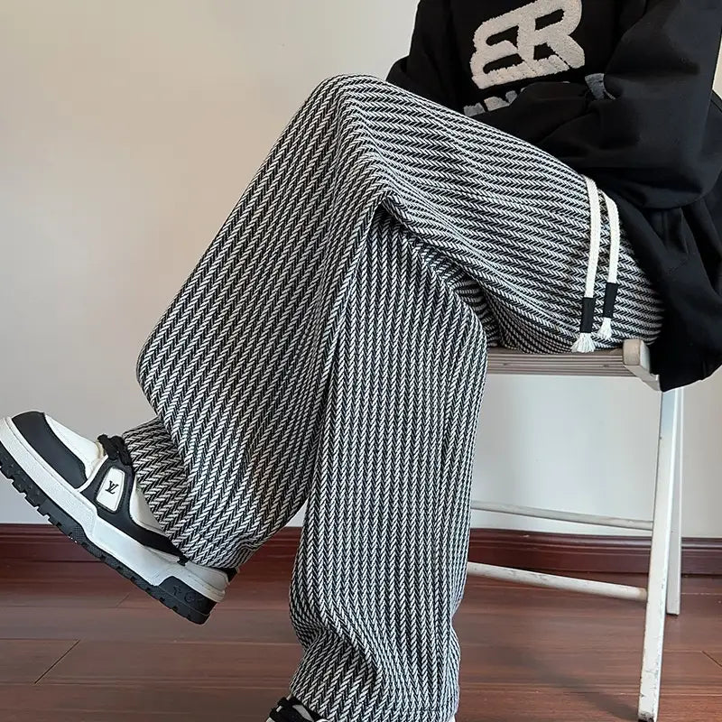 Men wide leg herringbone drawstring trousers in black and white with a classic herringbone pattern and adjustable drawstring cuffs.