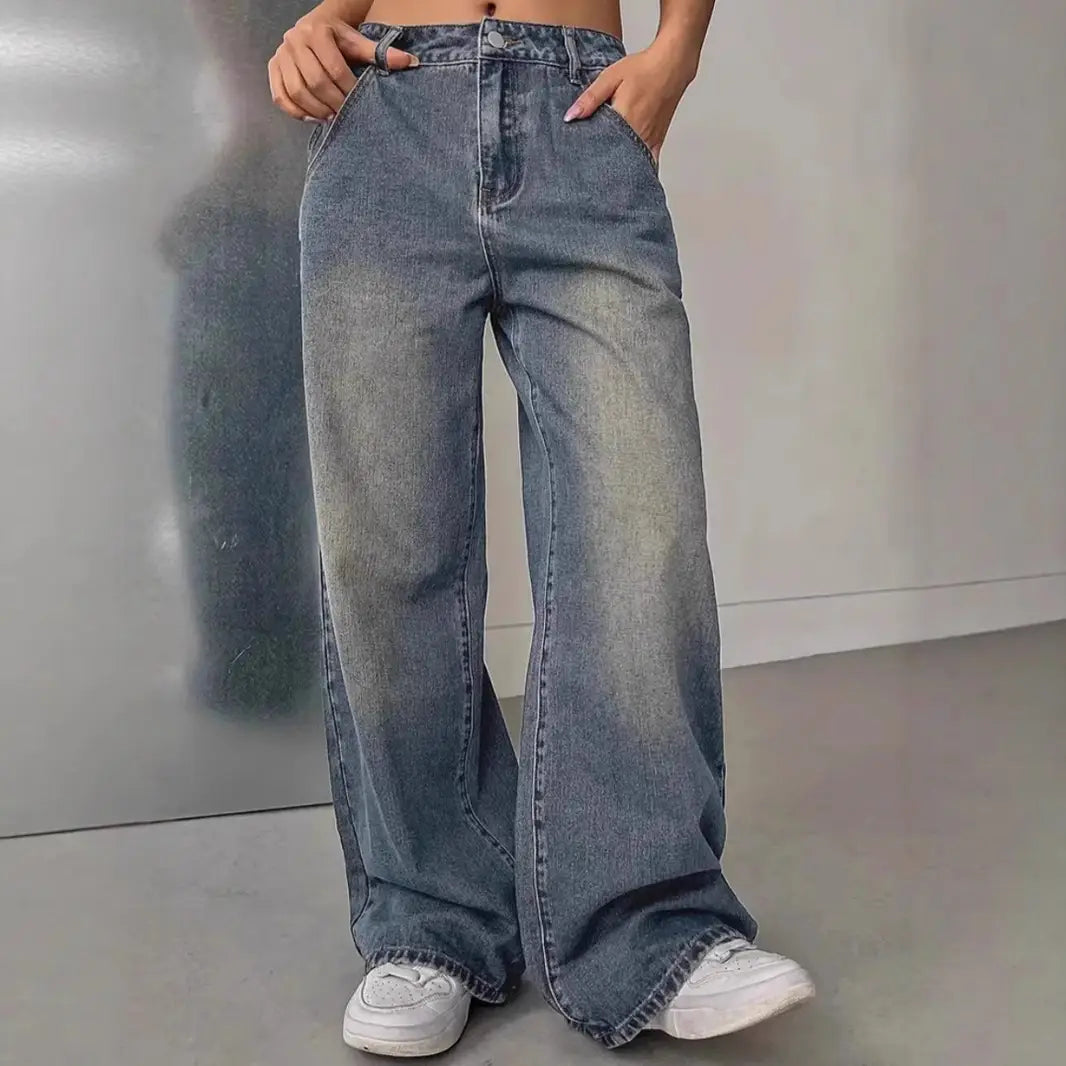 Jeans en denim vintage délavé à jambes larges en bleu délavé moyen avec un léger effet vieilli et des finitions d’ourlet brut.
