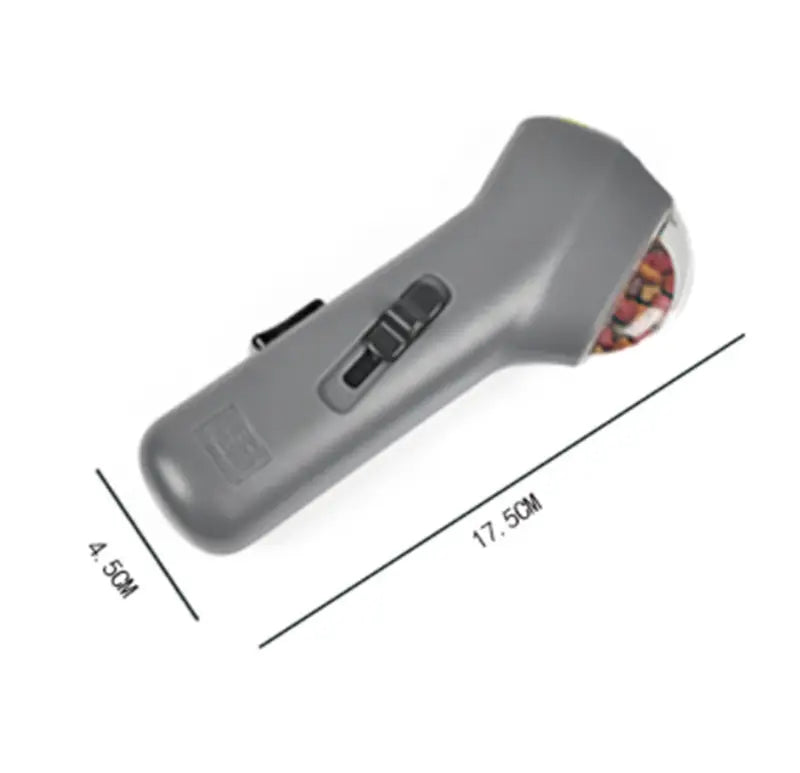 Gray plastic handheld dog training snack launcher pet treat shooter with a colorful patterned circular head.