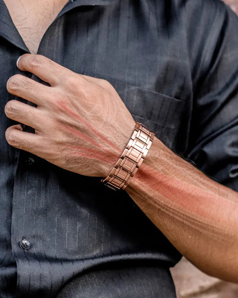 Rose gold stealth triple strength copper magnetic bracelet with sleek interlocking link design worn on man’s wrist