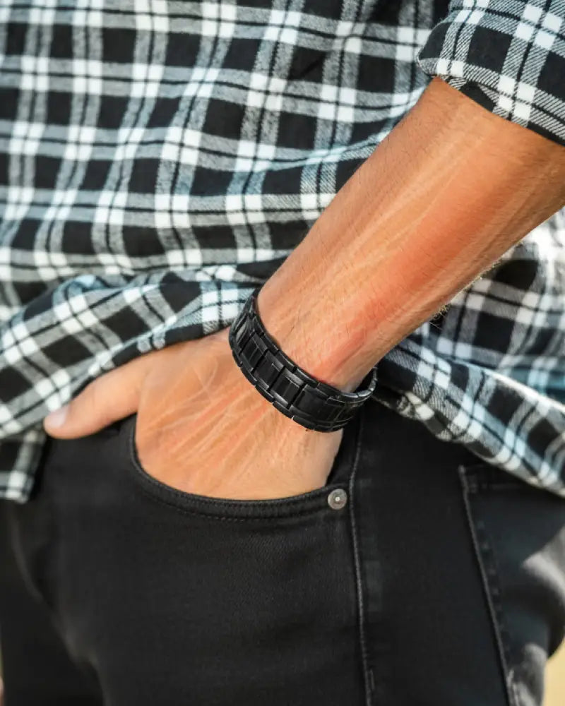 Men’s black titanium triple strength magnetic therapy bracelet featuring a metal link design worn on wrist