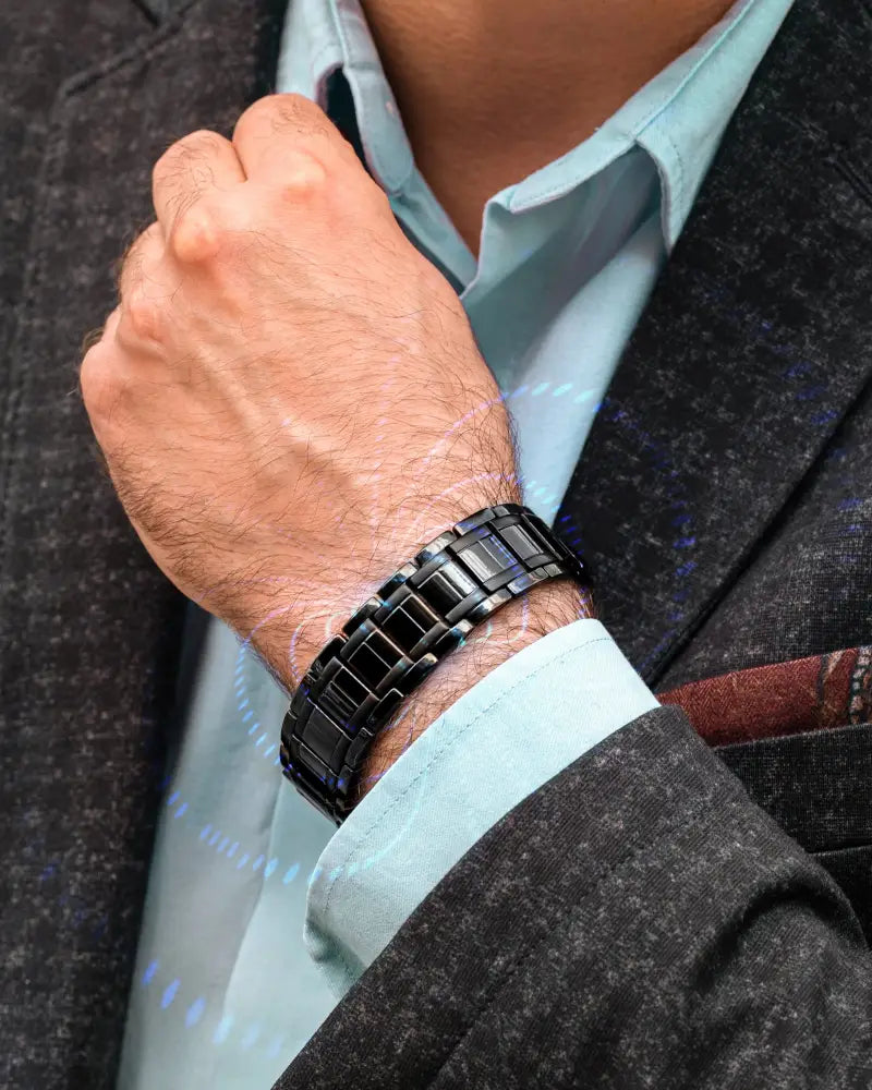 Men’s black titanium triple strength magnetic therapy bracelet in black ceramic link design worn on a man’s wrist