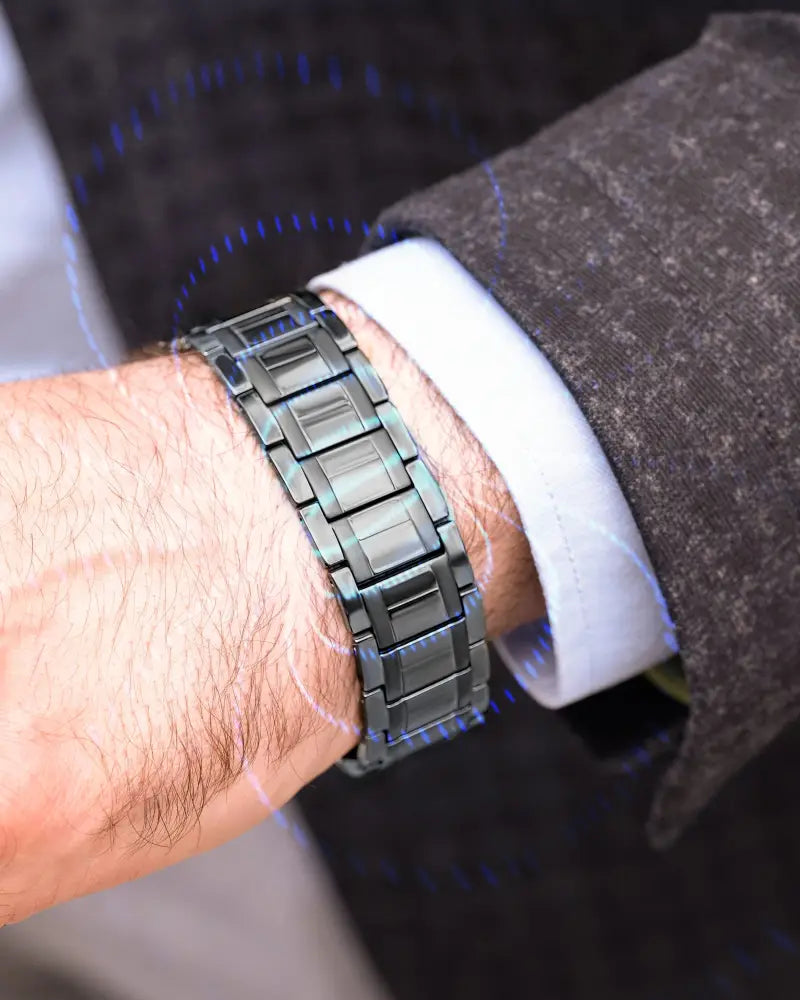 A sleek dark gray metallic watch band with polished interlocking links from triple strength gunmetal titanium magnetic therapy bracelet