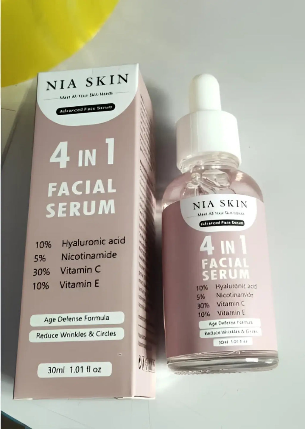 Nia skin 4-in-1 facial serum in clear glass bottle with white dropper and pink packaging containing vitamin c and niacinamide