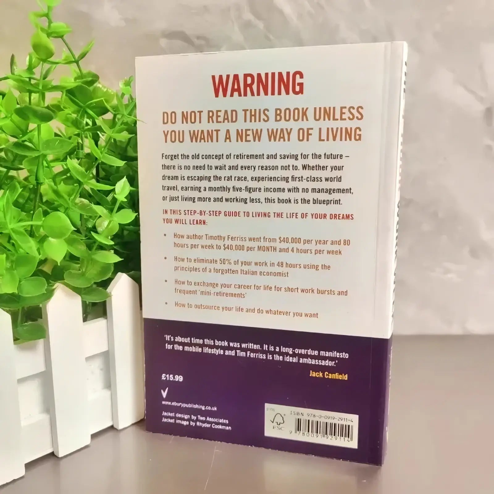 Back cover of the 4-hour workweek timothy ferriss paperback book showing white and purple hardcover with bold red warning title