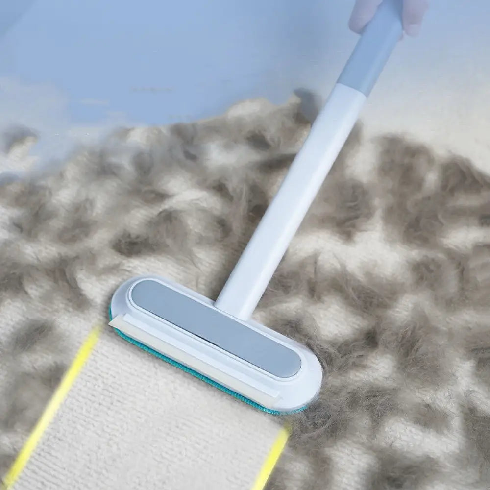 White and gray 4-in-1 multi-surface pet hair remover with teal bristle head cleaning a fluffy carpet surface