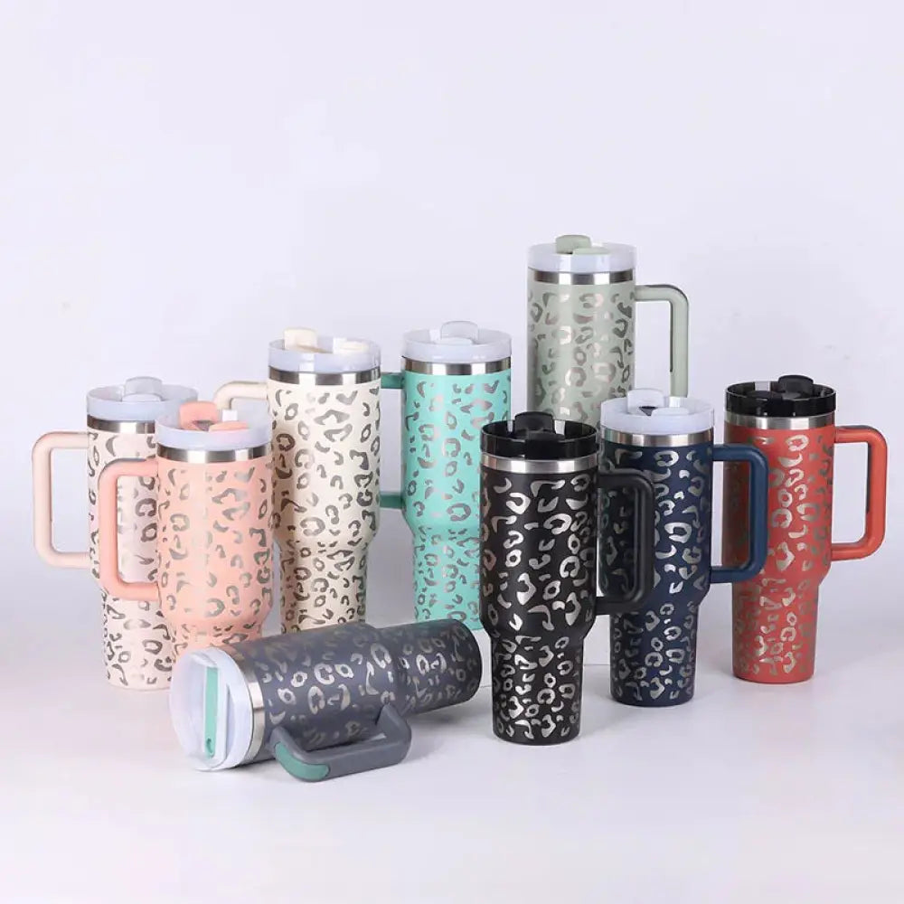 A collection of Arbaglobal 40 oz insulated travel mugs with handle and lid in various colors featuring leopard print design