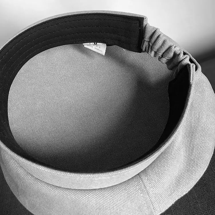 Casquette en tissu de laine grise avec doublure intérieure noire et bande élastique réglable, présentée depuis l’arrière en béret noir en laine pour peintre pour femmes.