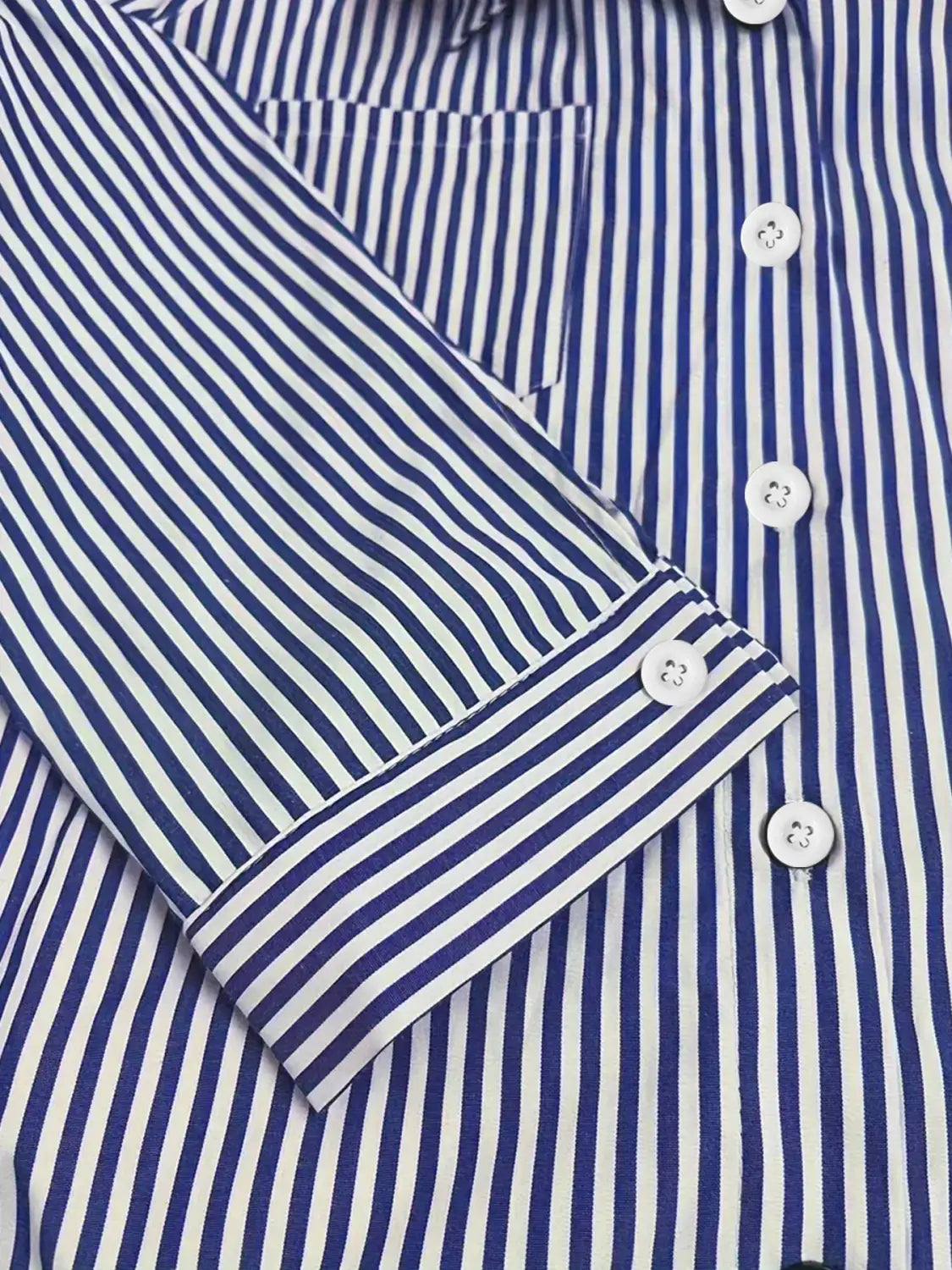 Chemise boutonnée à rayures verticales bleu et blanc à manches longues avec col classique en tissu soigné, comportant des boutons assortis, adaptée à un usage décontracté.