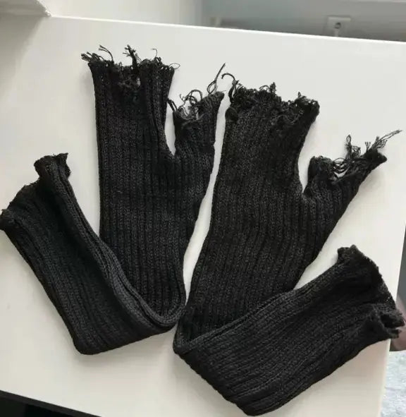 black tattered knit fingerless gloves unisex in black ribbed knit with frayed edges shown from the back side