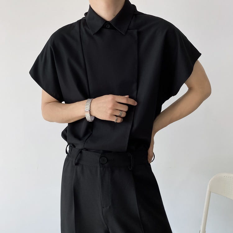 Black short-sleeved button-up shirt with a sleek modern cut and subtle pleats down the front in a men oversized long sleeve button up shirt style.