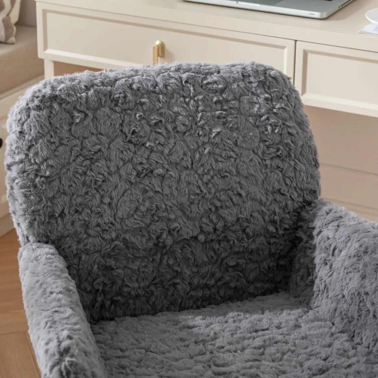 Chaise de bureau en fausse fourrure gris clair, avec une housse de fauteuil duveteuse grise et une surface moelleuse texturée, ainsi qu'une base en métal doré.