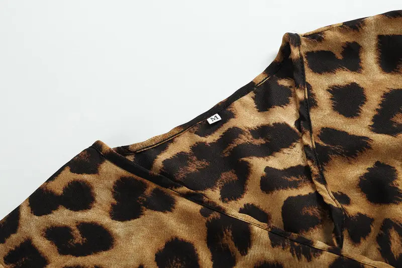 A leopard print v neck long sleeve chiffon wrap dress featuring a soft flowing fabric and a classic v neckline.
