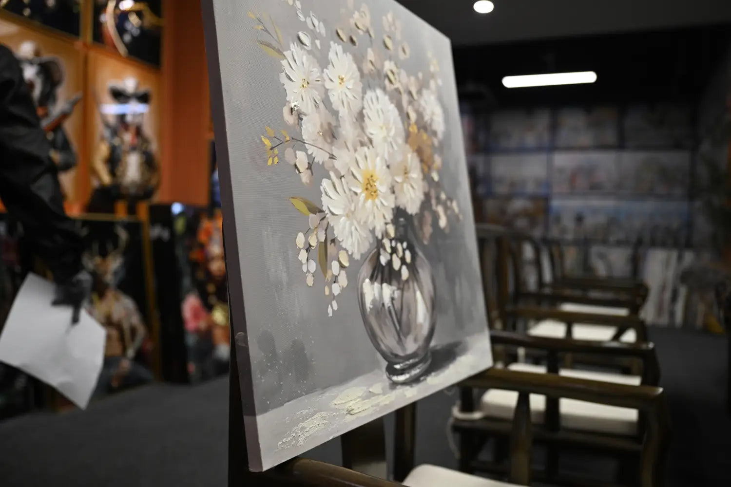 Eine zarte Wandkunst auf Leinwand 24x24 mit einem Strauß aus weißen und cremefarbenen Chrysanthemen in einer durchscheinenden Glasvase mit sanften Pinselstrichen vor einem gedämpften grauen Hintergrund.