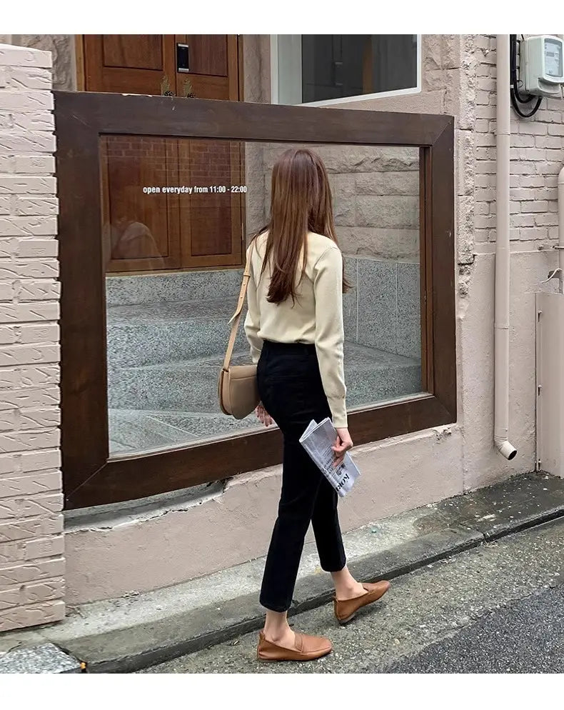 Beige Schultertasche mit strukturiertem minimalistischem Design und weichem Leder, kombiniert mit schwarzen Samtgefütterten High-Waist-Jeans-Leggings.