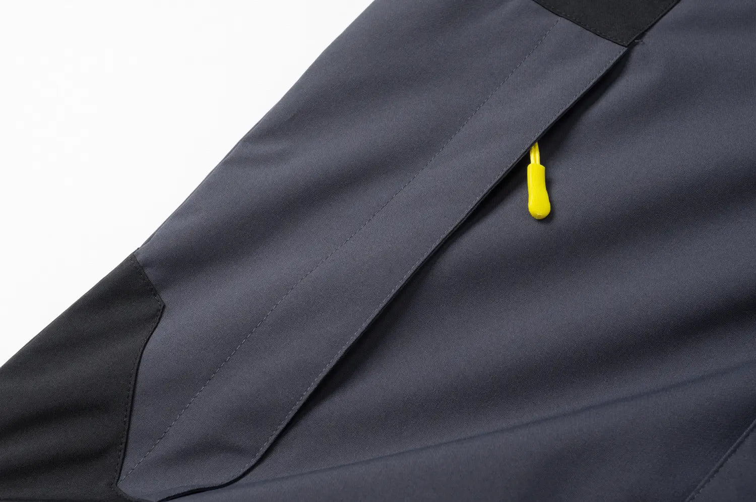 Veste de plein air imperméable à capuche gris foncé pour hommes et femmes, avec un panneau contrastant noir et une tirette de fermeture éclair jaune vif.
