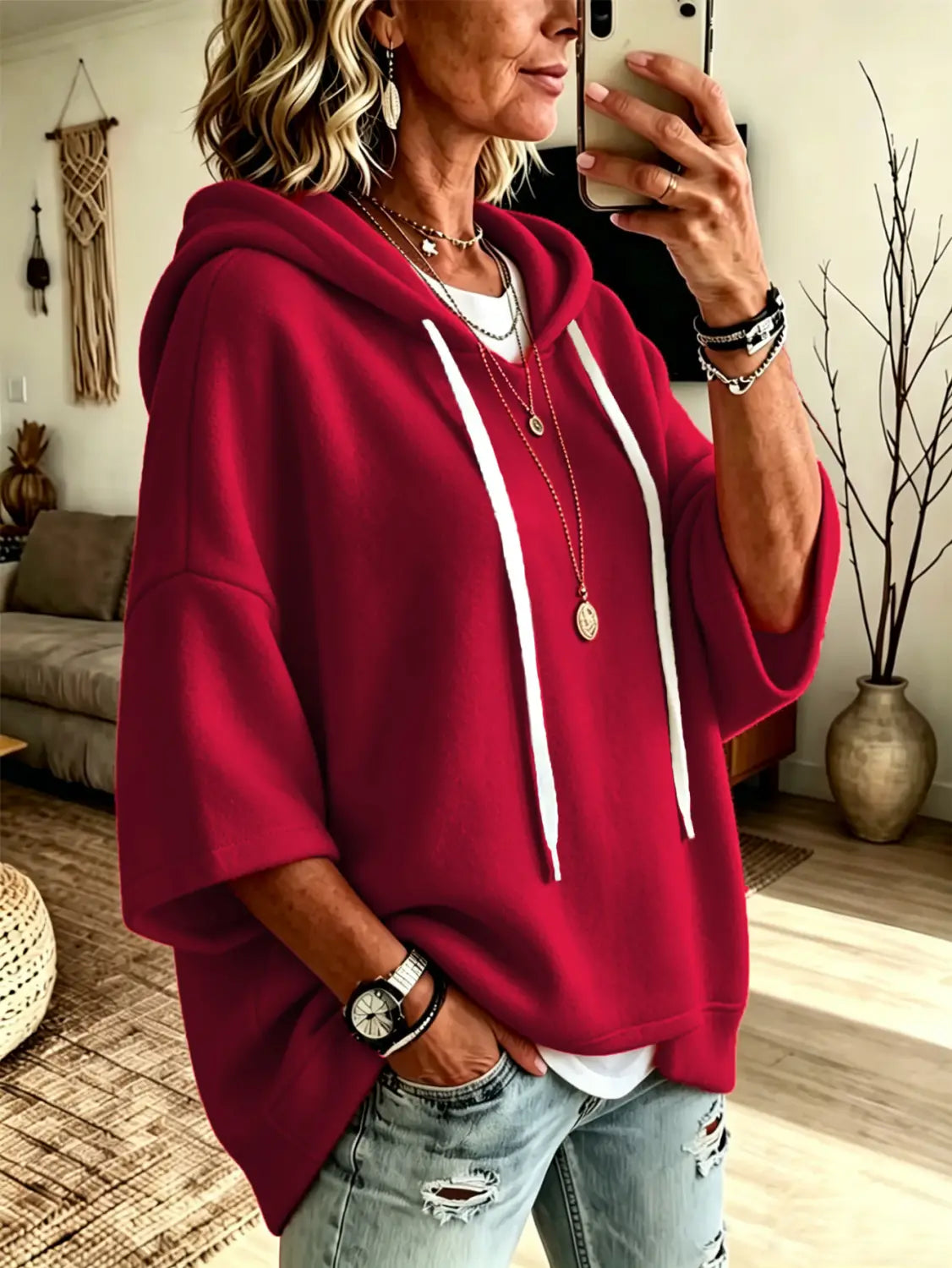 A vibrant red oversized fleece hooded top with three-quarter sleeves featuring a loose-fitting silhouette and white drawstrings.