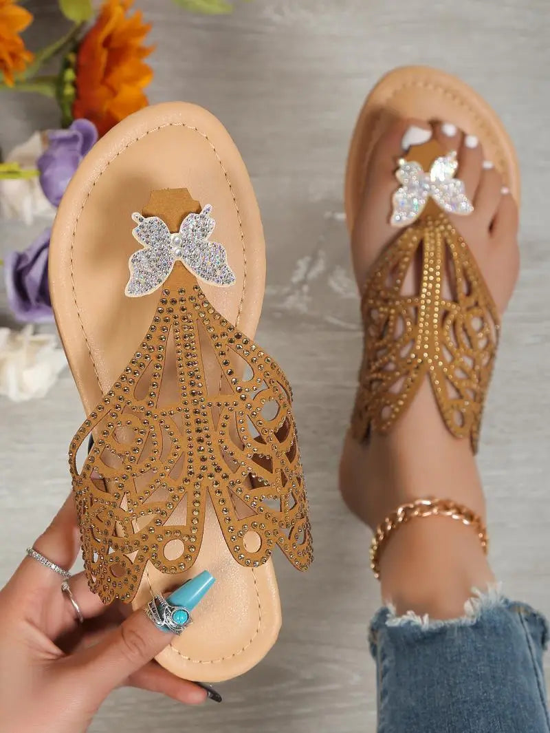 Women’s gold rhinestone hollow flat slip on sandals featuring butterfly embellishments and intricate cutout patterns.