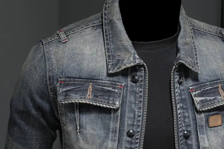 A distressed dark wash denim jacket for men featuring a classic collar, button and zipper closure, and two front pockets with stitched detailing.