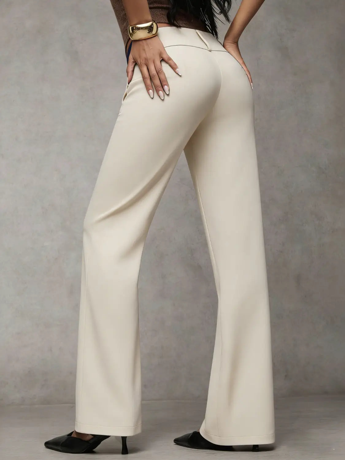 Cream-colored high waist wide leg work pants made of smooth sleek fabric with subtle front seam detailing for casual wear.