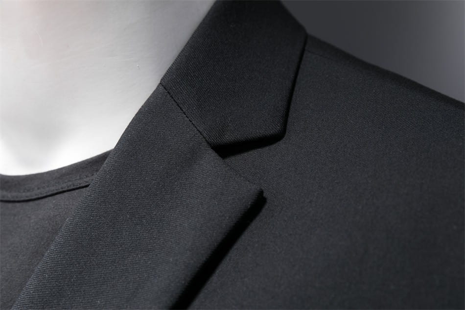 Chaqueta de vestir empresarial de pana negra con ajuste slim, cuello estructurado y definido, y tejido suave adecuado para uso profesional.