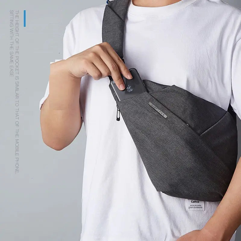 Bolsa bandolera empresarial para el pecho, minimalista y a prueba de robos, de tejido texturizado gris, con diseño elegante y marcas sutiles en el frente.