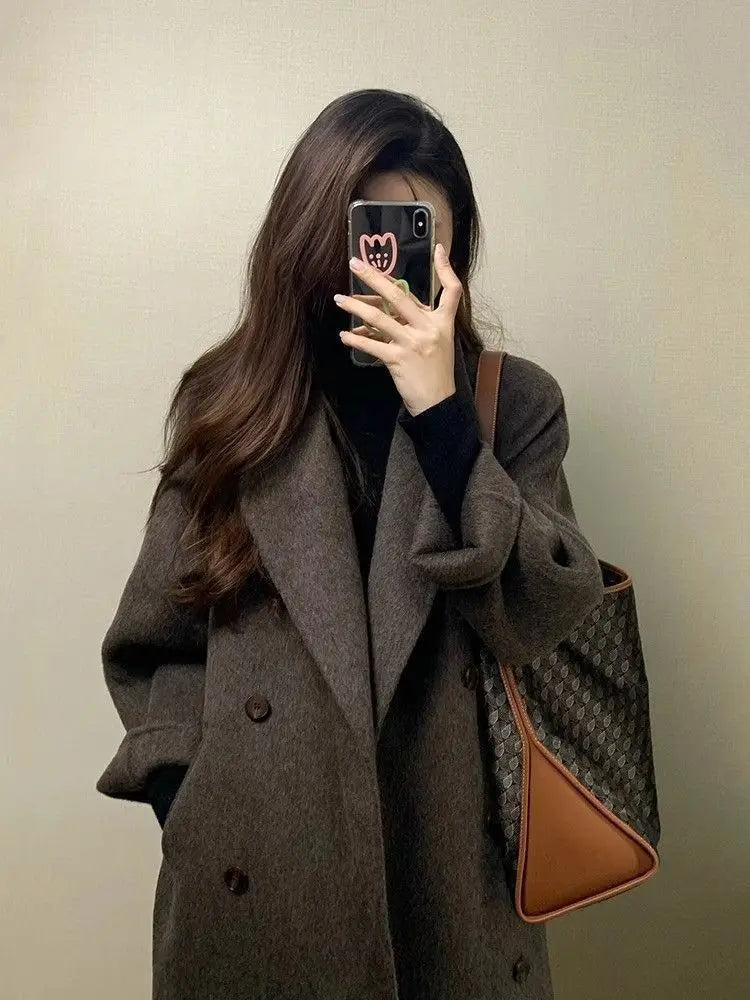 Braune Gucci-Totetasche mit dem charakteristischen Monogramm-Muster und beigem Lederbesatz, kombiniert mit dem Damen-Wollmantel mit doppelreihiger Knopfleiste.