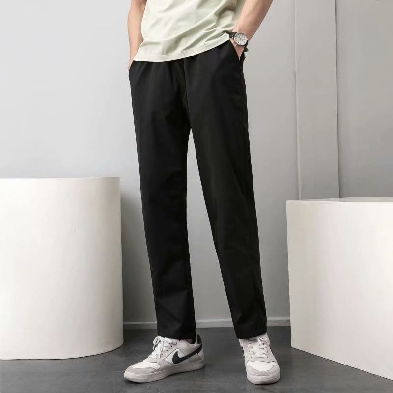 pantalon chino noir fuselé à coupe ample et à de légers plis, adapté comme pantalon décontracté.