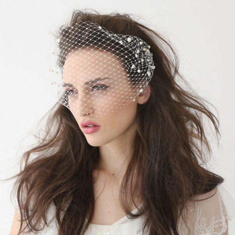 short pearl beaded mesh bridal veil features a delicate white lace-like mesh with pearl embellishments and a gold hair comb.
