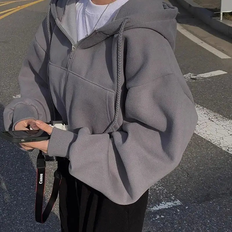 Grauer Zip-up-Kapuzenpullover mit weichem, strukturiertem Stoff und dazu passenden Kordeln, kombiniert mit einem dunkelblauen Samt-Velours, wattierten Kapuzenpullover mit schmaler Passform.