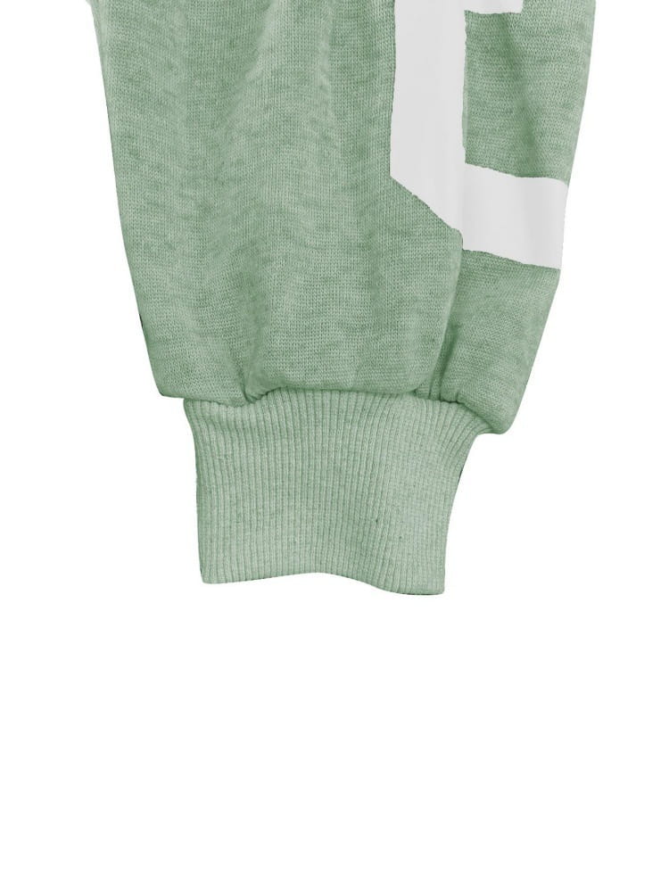 Jogger chiné vert clair avec une rayure graphique blanche sur le côté, associé à un sweat-shirt à capuche zippé imprimé graphique.
