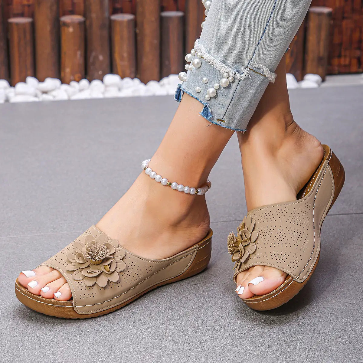 Sandalias de cuña con flores en beige, adornadas con motivos florales, con parte superior de cuero perforado y suela de goma marrón, diseñadas como sandalias retro de cuero perforado para playa.