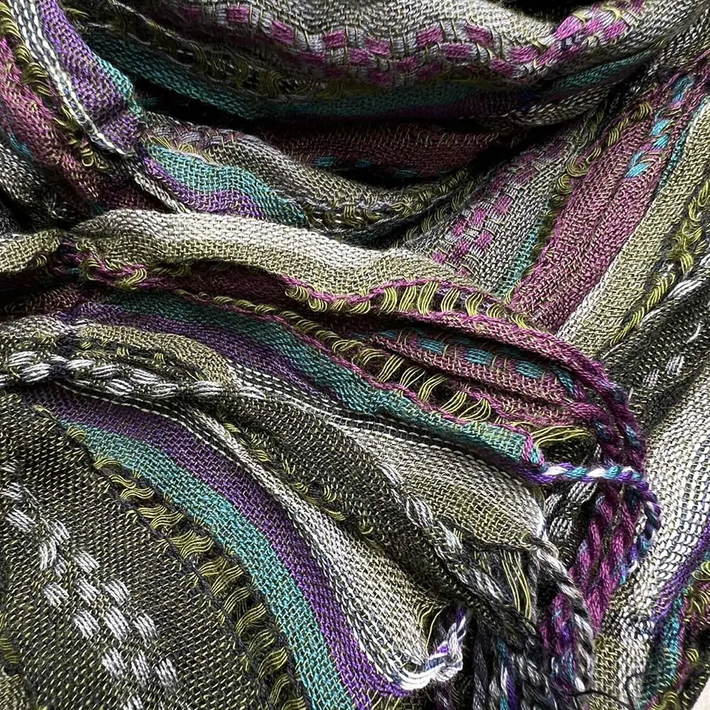 Écharpe froncée en jacquard tissé d’un vert olive, avec des rayures multicolores aux tons de violet, vert, turquoise et gris, et une broderie détaillée le long des bords.