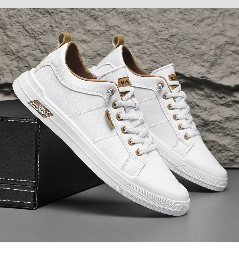 Men’s white minimalist casual sneakers made of canvas with tan leather accents and gold tone eyelets.