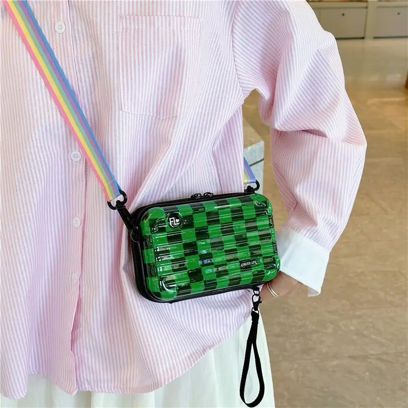 Green checkered transparent mini suitcase crossbody bag with black trim and rainbow strap.