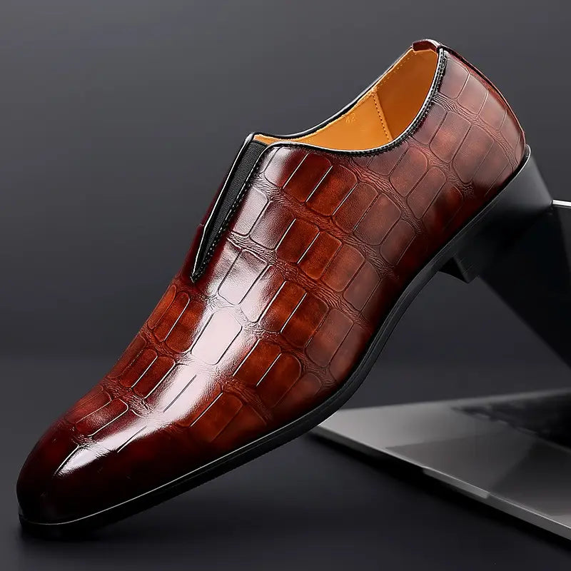 Brown crocodile embossed leather men’s dress slip on loafers with a sleek polished finish and black accents