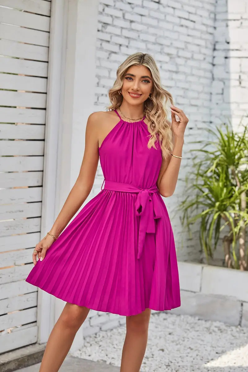 A vibrant fuchsia halter neck pleated chiffon mini dress with a matching belt tied at the waist.