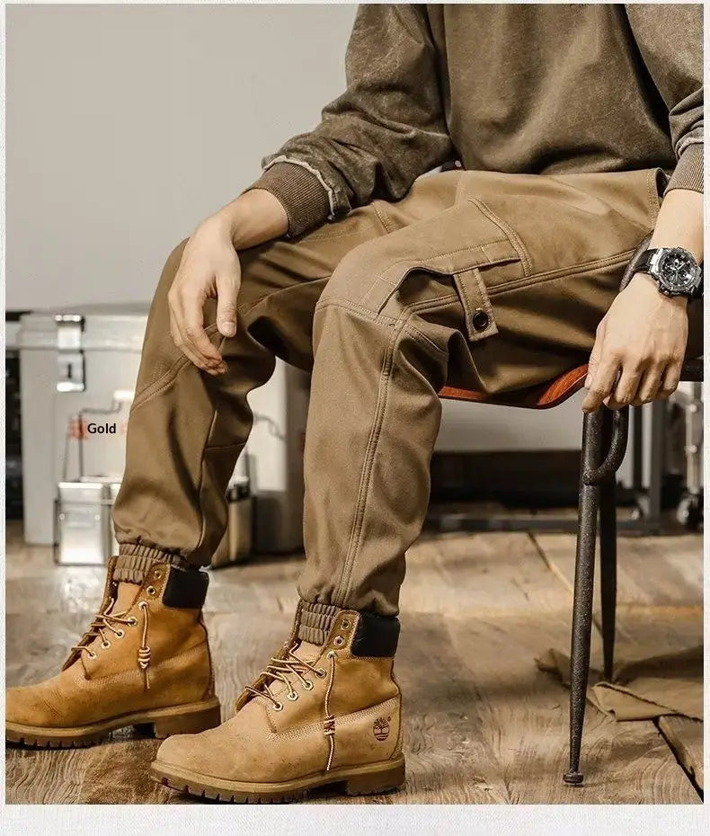 Pantalons cargo pour hommes à coupe ample, style décontracté et vêtement de travail, associés à des bottes de travail Timberland tan, avec des lacets robustes et un logo classique sur le côté