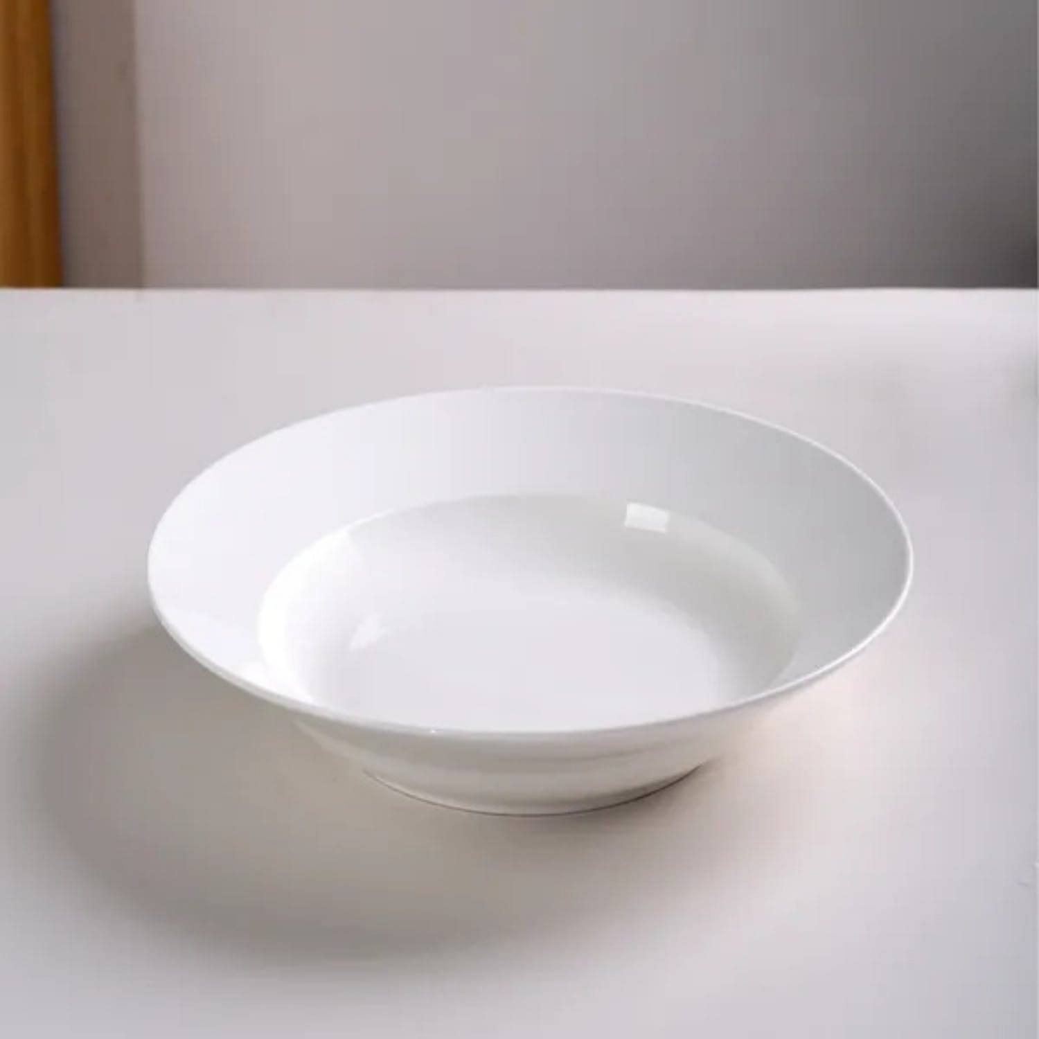 A sleek glossy white ceramic bowl with a wide rim and shallow depth from a white dinner plates set of 6 ceramic 9.5 inch bowls.